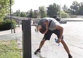 Un hombre se refresca ante el intenso calor.