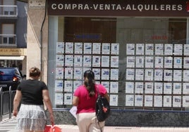 Una mujer observa los precios de mercado en una inmobiliaria salmantina.