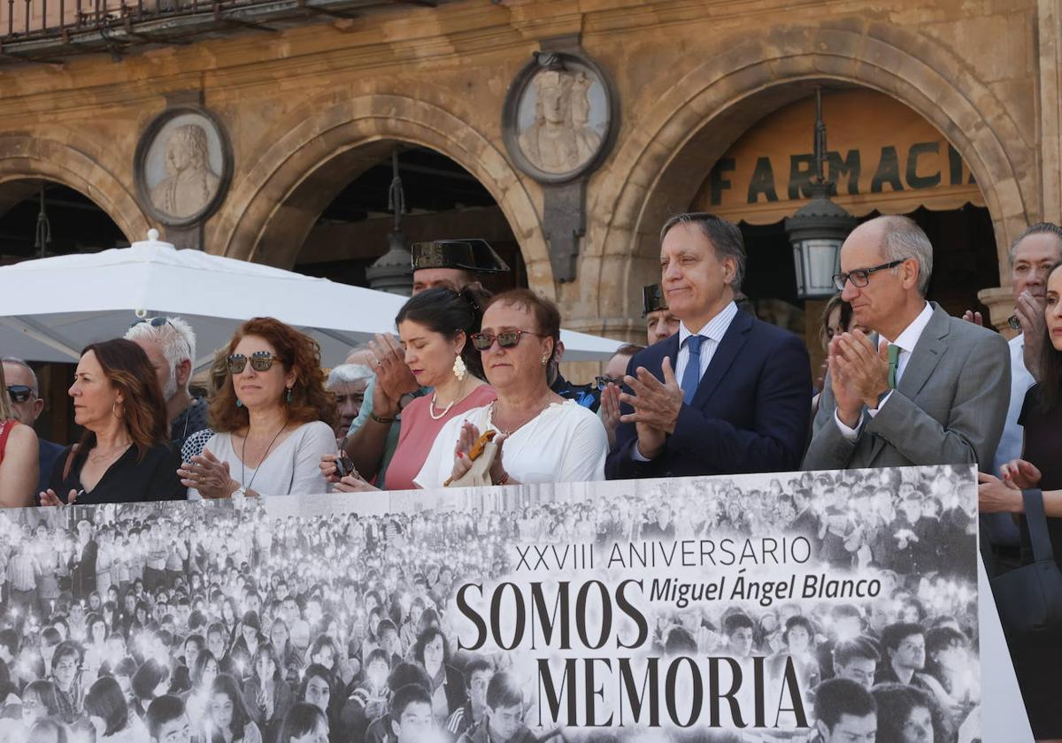 Varias autoridades institucionales, encabezadas por el alcalde, Carlos García Carbayo, posan con familiares afectados tras la pancarta.