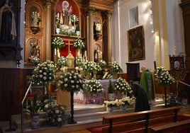 Altar mayor de la iglesia San Juan de la Cruz de Alba de Tormes con las rosas blancas.
