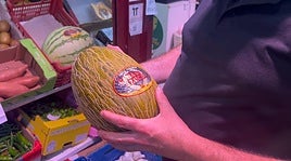 Javier Carrasco, frutero del Mercado de San Juan, sosteniendo un melón.
