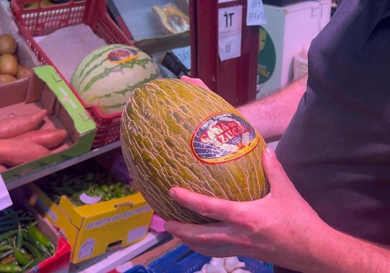 Javier Carrasco, frutero del Mercado de San Juan, sosteniendo un melón.