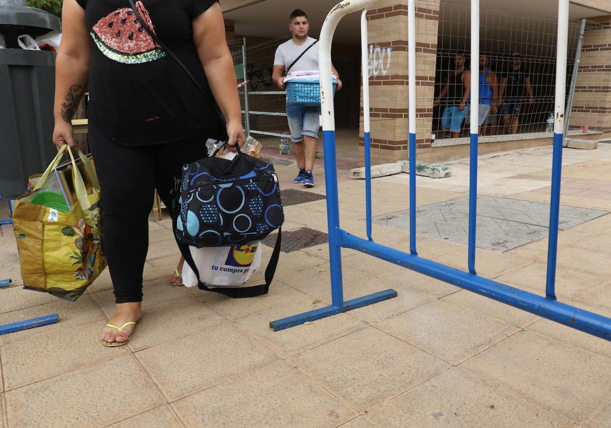 Una mujer carga con sus efectos personales tras ser desahuciada.