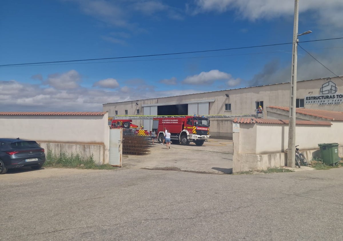 Imagen principal - Efectivos y vecinos de la zona en el lugar del incendio de una nave en Garcihernández.