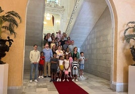 Las familias del programa «Vacaciones en Paz» junto a la corporación municipal en hall del Ayuntamiento