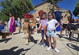Dos pequeños posando al lado de los animales