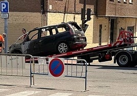 Imagen de la retirada del coche calcinado en la calle Colombia.