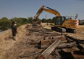 Una máquina, retirando las traviesas de la antigua vía de ferrocarril.