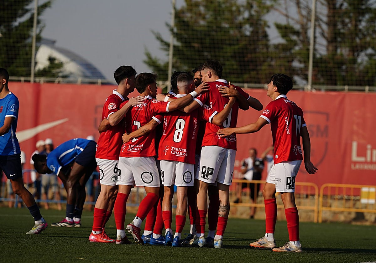 Piña de los jugadores de Unionistas celebrando el gol de Pere Marco.