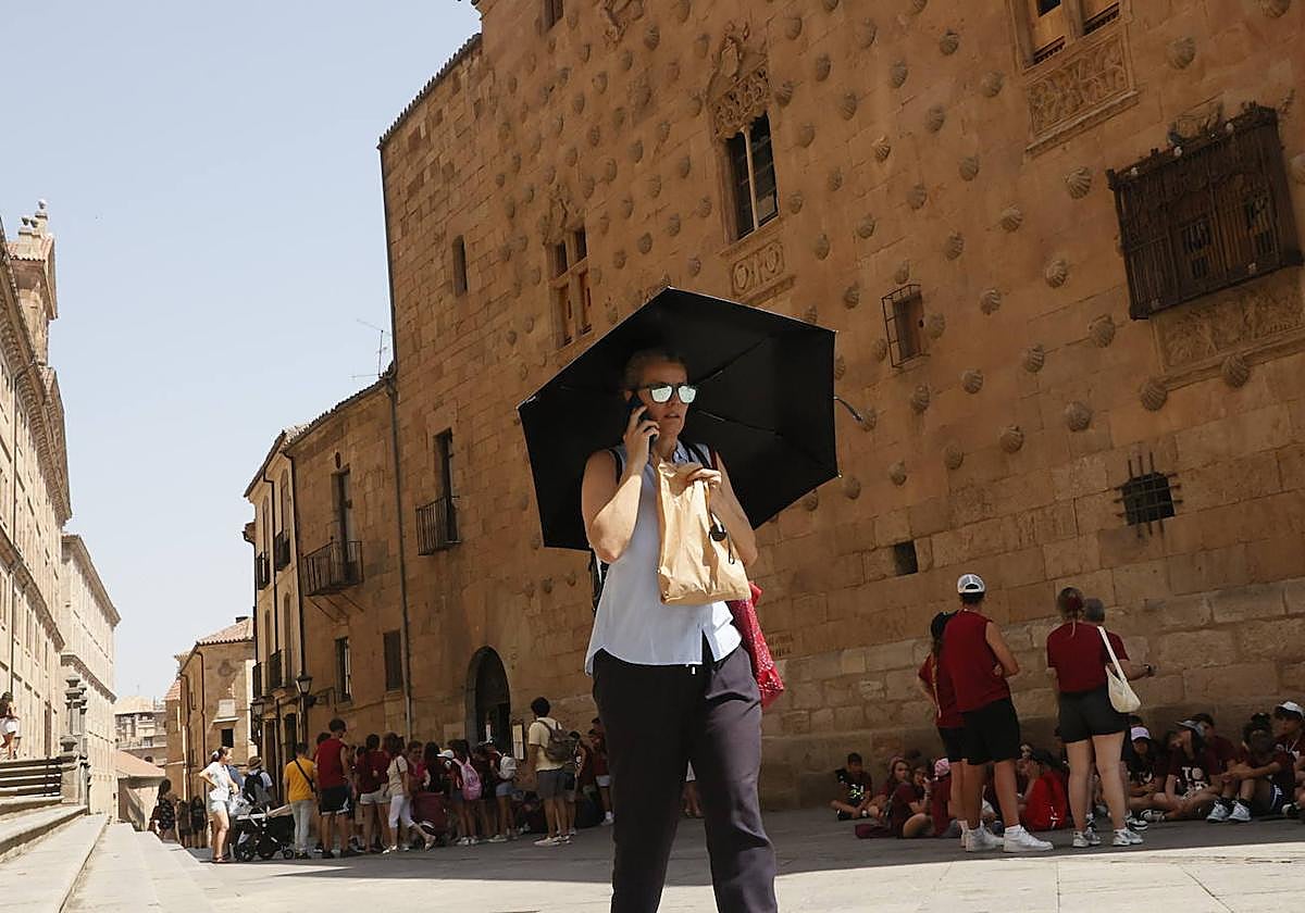 Una mujer se protege ante el calor con un paraguas.