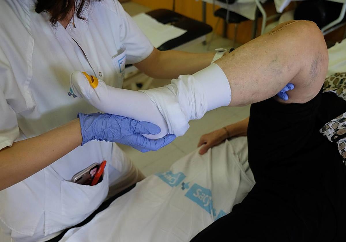 Personal del Hospital de Salamanca trabaja en la rehabilitación de una rodilla en un paciente mayor.