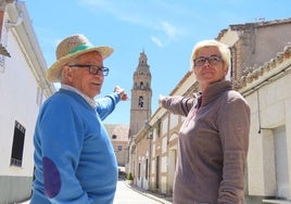 Dos vecinos apuntan con sus dedos a la torre de la iglesias de Palaciosrubios.