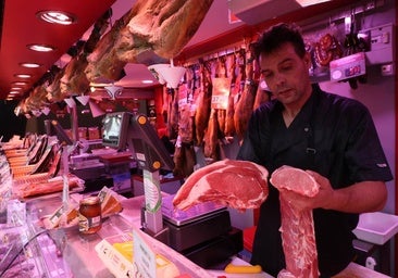Un carnicero del Mercado sostiene los dos productos que más han subido en su estand.