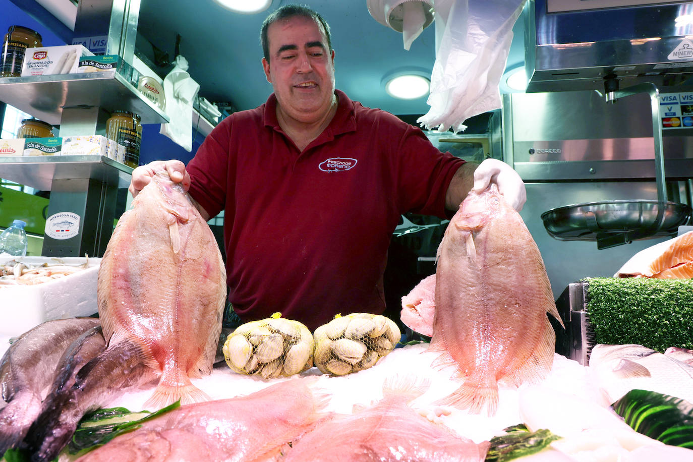 El pescadero de Pescados Moreno sujeta dos gallos.