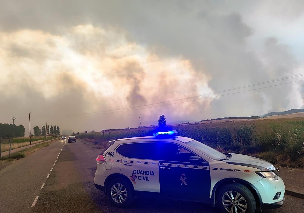 Imagen del incendio con el coche de la Guardia Civil.