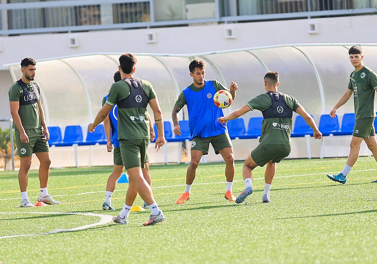 Los jugadores de Unionistas realizan un ejercicio de calentamiento antes del entrenamiento de ayer.