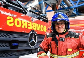 José Santos, vestido con su ropa de trabajo en el Parque de Bomberos de Salamanca, junto a uno de los camiones que conducen para acudir a una emergencia y sofocar el fuego.