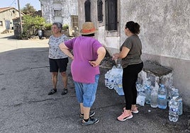 Tres vecinas de Cerezal de Puertas, con varias garrafas de agua, dispuestas a ayudar.