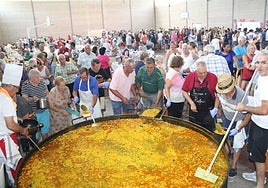 Los mayores de la asociación, en pleno reparto de la paella.