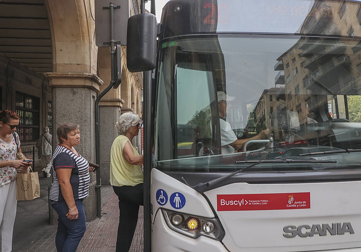 Viajeros, subiendo a un autobús metropolitano.