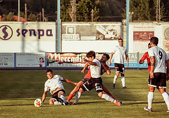 Lara y Carrasco pelean por un balón en el centro del campo.