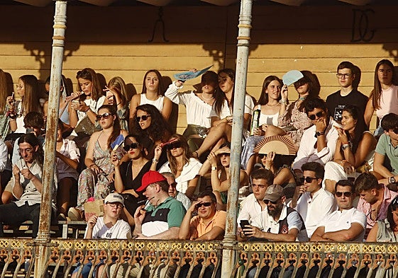 Jóvenes, en la grada de sol de la plaza de toros de La Glorieta.