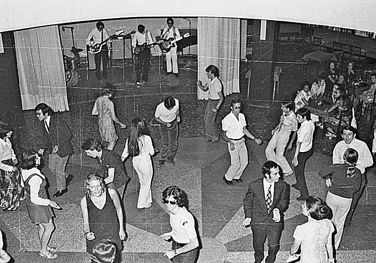 Unos jóvenes bailan y otros miran en una de las fiestas organizadas por Cursos de Verano de la Universidad en 1971.