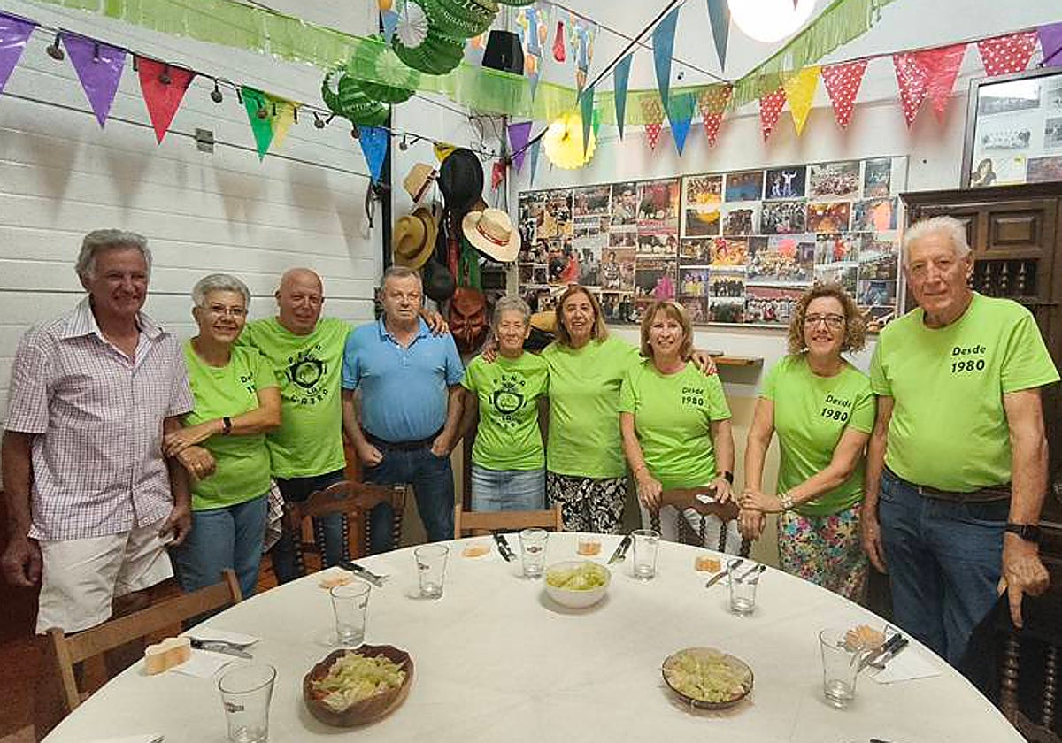 Algunos de los miembros de la peña La Cabra junto a la mesa antes de compartir la cena.