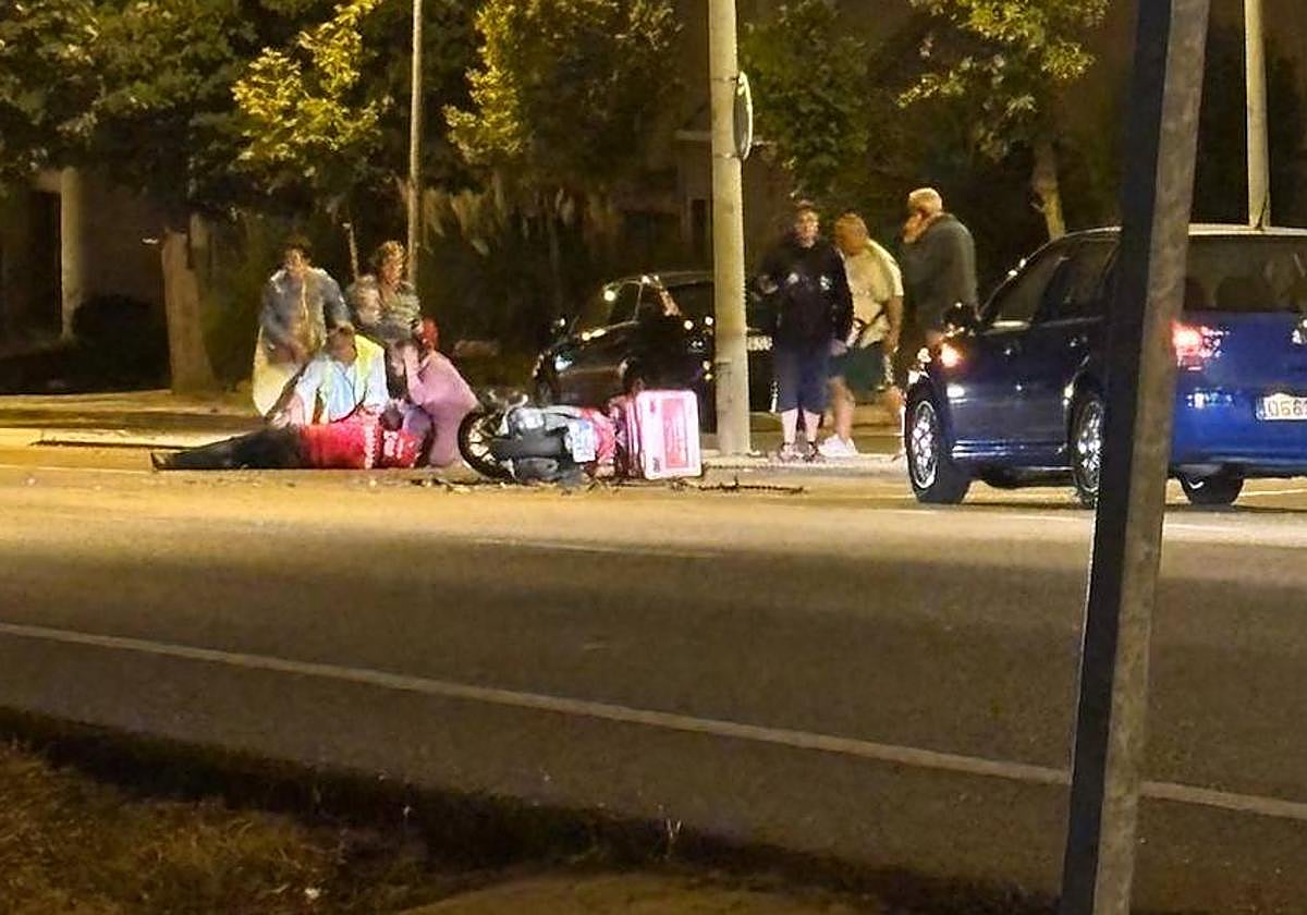 El conductor de la moto tirado en el suelo.