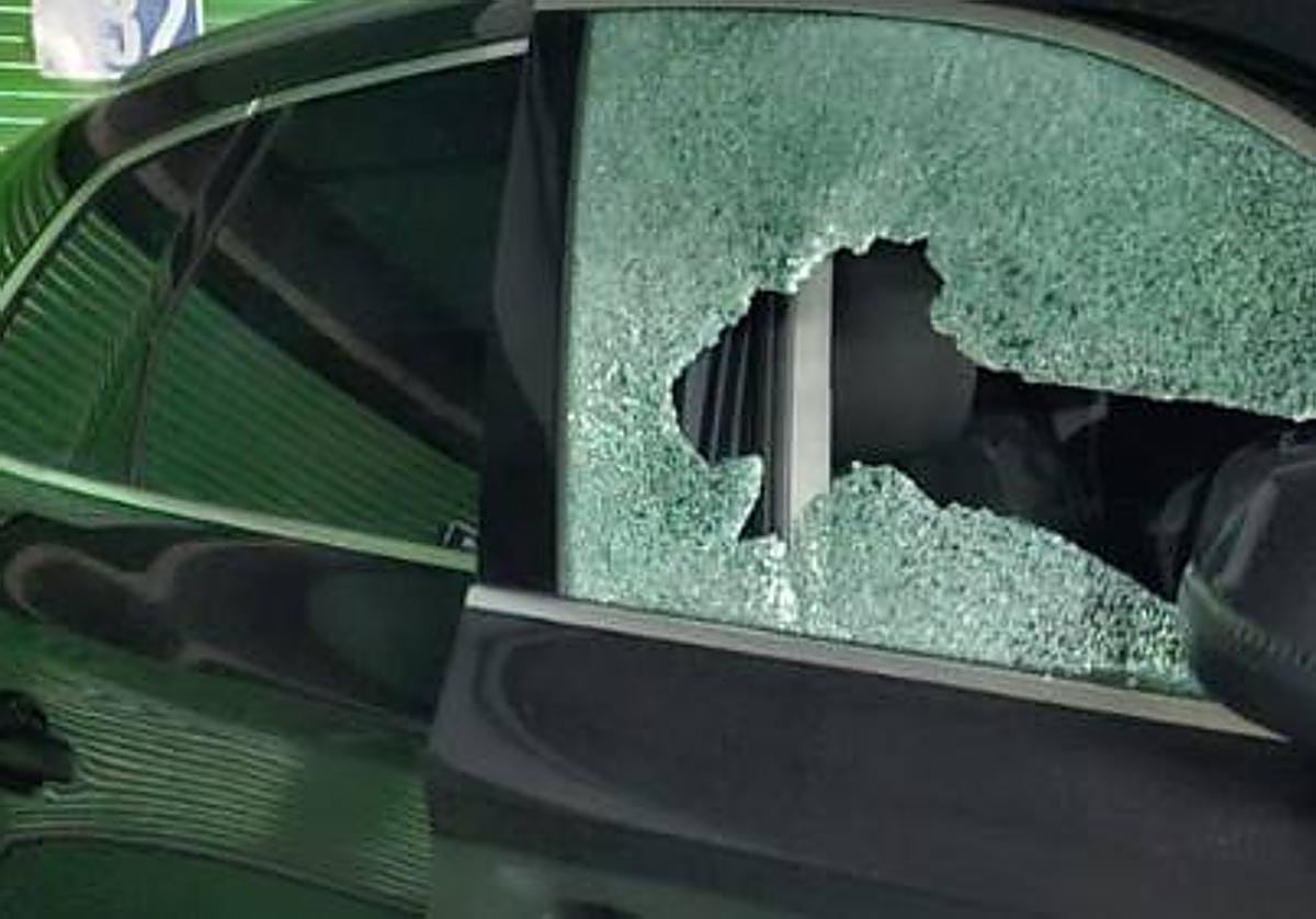 Uno de los vehículos afectados con la luna destrozada.