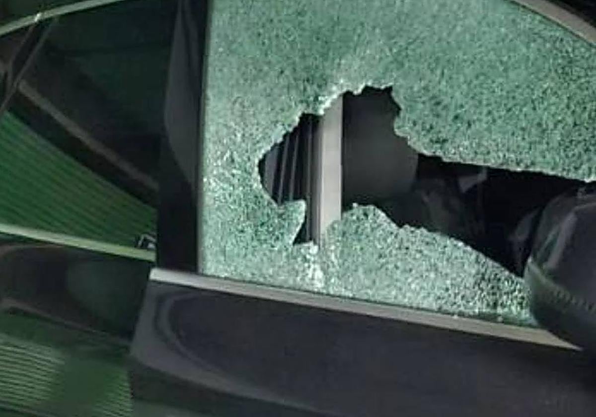 Uno de los vehículos afectados con la luna destrozada.