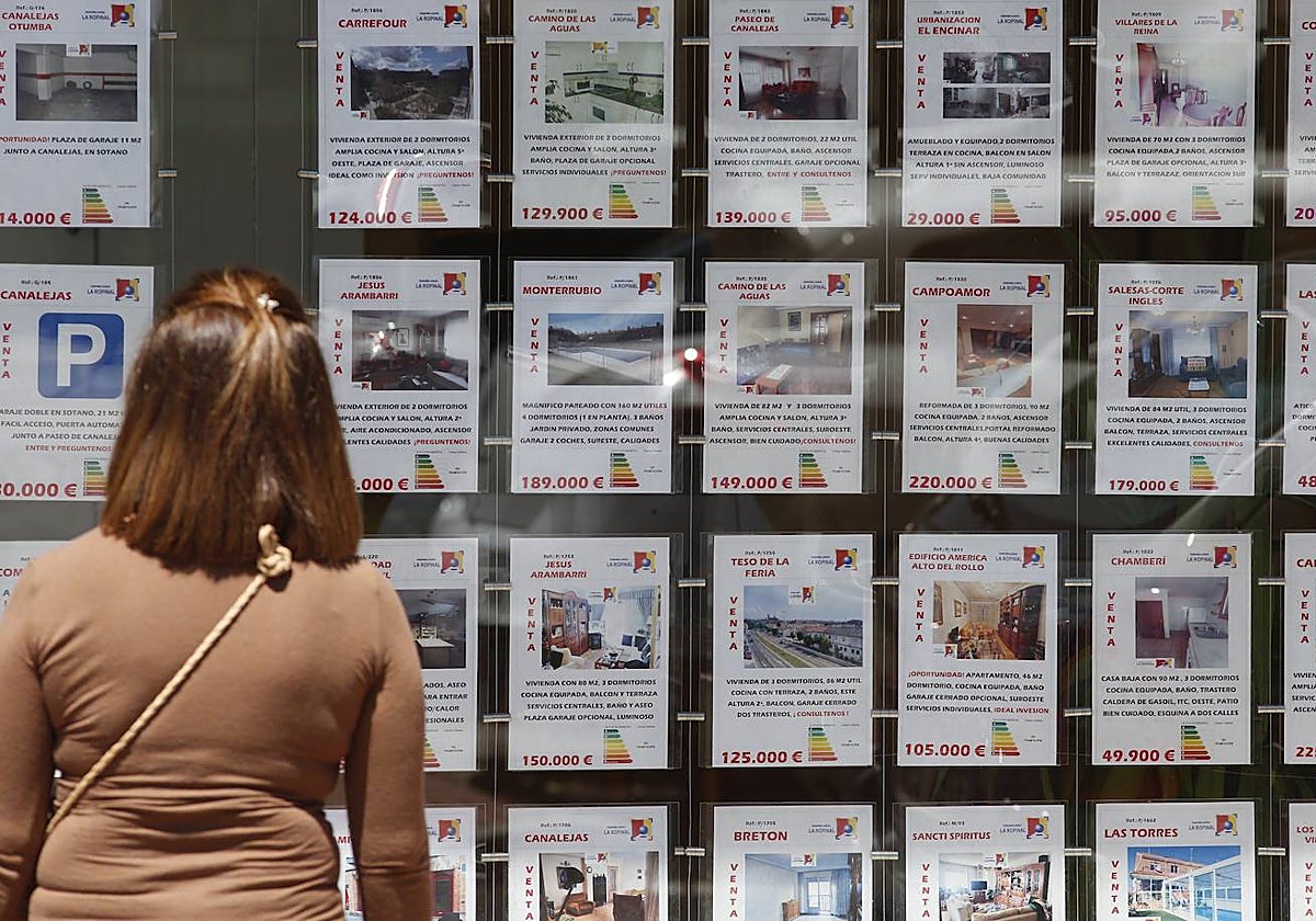Una mujer observa los anuncios de una inmobiliaria.