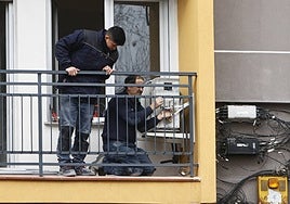 Dos trabajadores instalando un sistema de aire acondicionado.