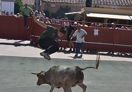 Un mozo salta sobre uno de los animales del encierro.