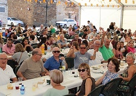 Los vecinos disfrutaron de la comida protegidos del sol bajo la carpa.