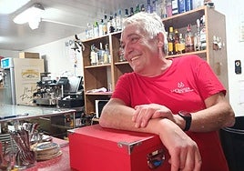 'Mole' sonríe detrás de la barra de 'La Quinta' junto a los libros que le han regalado por su jubilación.