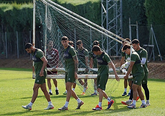 Los jugadores de Unionistas, con Pachón al frente, cargan una portería en el anexo al Tori.