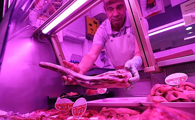 Un carnicero muestra un rabo de toro.