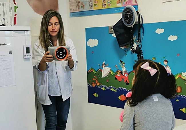 Una profesional porta el dispositivo, adaptado a los niños con rostros sonrientes.