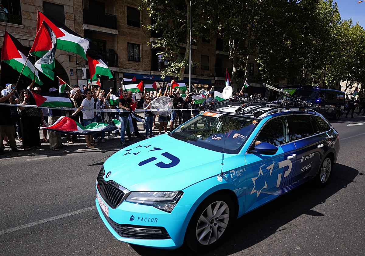 Uno de los coches del Israel - Premier Tech pasa junto a las protestas pro palestinas.