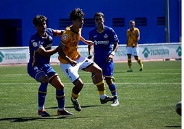El jugador de Unionistas Óscar Lorenzo espera un pase mientras es defendido por un zaguero del Getafe.