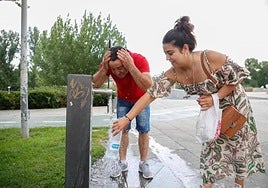 Personas refrescándose en una fuente ante las altas temperaturas.