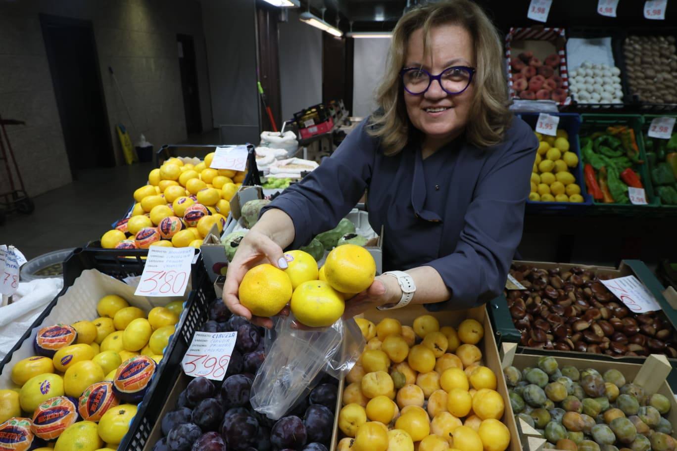 Una frutera del Mercado muestra unas mandarinas de Valencia.