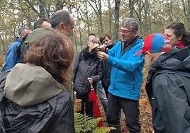 El experto José Ignacio Gómez Risueño muestra un ejemplar a un grupo de aficionados a la micología.