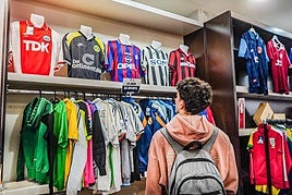 Un joven mira las camisetas retro.