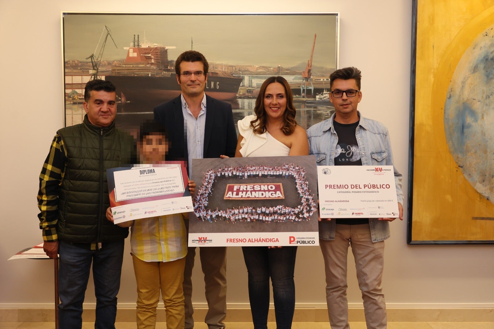 Gabriel Martín, gerente de catering Gabriel y Rafael Sánchez Riesco, responsable de infraestructura y medios de Cobadu, entregan el Premio del Público a la fotografía de Fresno Alhándiga. Reciben el galardón el alcalde la localidad, Julio Castelló, y la concejala de festejos, Sheila Mateos. En la imagen ganadora, aparecen más de un centenar de vecino alrededor de un bocadillo gigante de más de 60 metros.