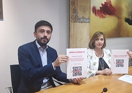 Fran Díaz y Carmen Ávila muestran el código QR para la recogida de firmas.