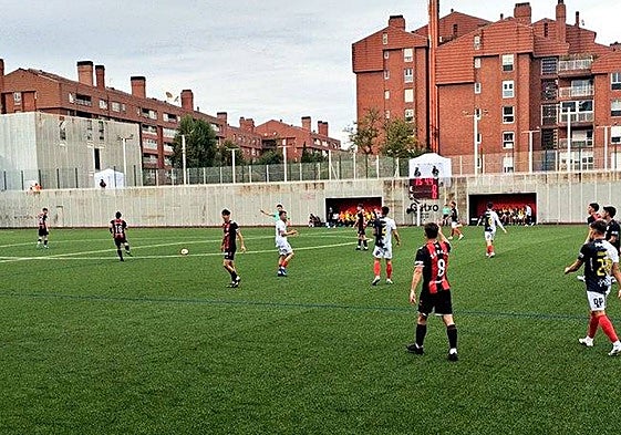 Jugadores de ambos equipos sobre el municipal de Gobela durante el encuentro.