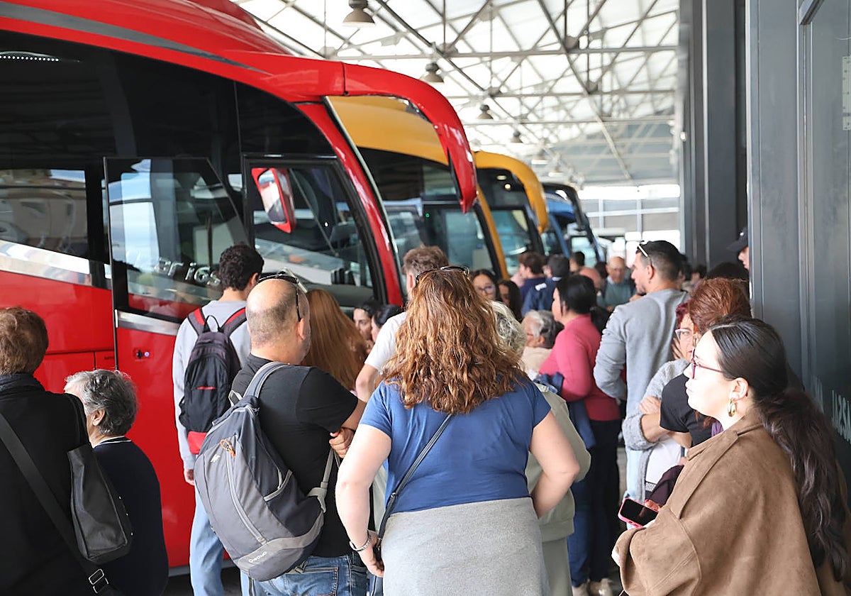 Viajeros esperando en los andenes de la estación de autobuses.
