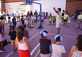 Un monitor de una ludoteca municipal realizando juegos con los niños.